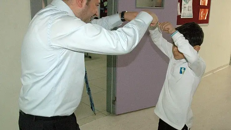 'Öğrencilerle selamlaşıp derse başlıyor'