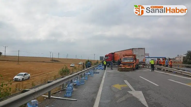 Tırdan yola dökülen su dolu damacanaları kendi araçlarına aldılar